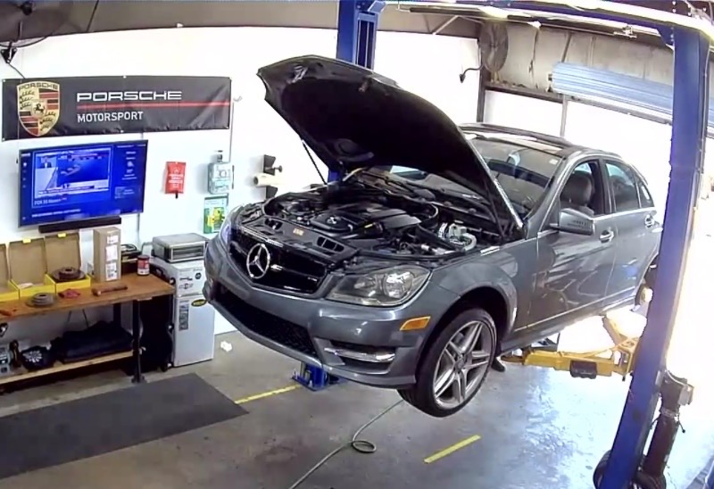 Mercedes-Benz SUV with its hood open on the garage lift
